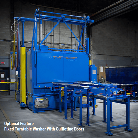 Fixed turntable washer with two guillotine doors for flow-through operations